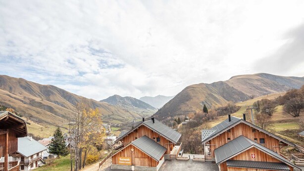 Un bâtiment de style chalet en bois, sur lequel est apposée une enseigne indiquant qu’il s’agit d’un « chalet et spa Sunweb ».
