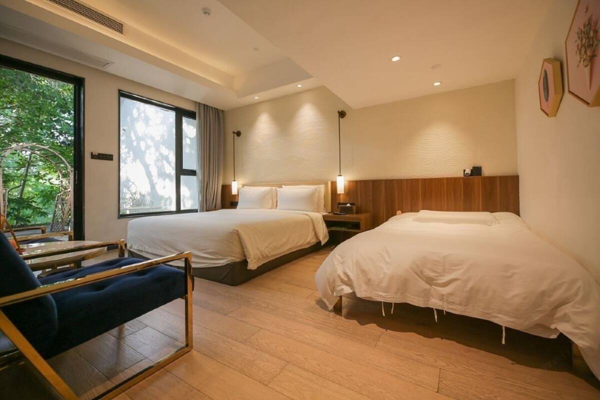 Ein Hotelzimmer mit zwei Betten, einem Schreibtisch und einem Stuhl.