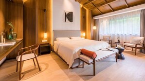 A modern bedroom with a large bed, a desk, chairs, and a window with curtains. - Xishangyunjian (Hangzhou)