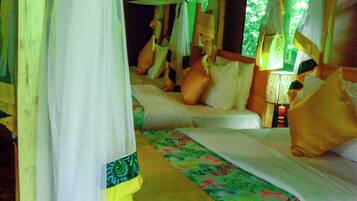 A bed with a canopy, pillows, and a floral bedspread.