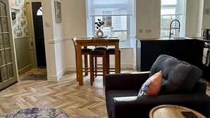 En moderne stue med sofa, sofabord og spiseplads med bord og stole.