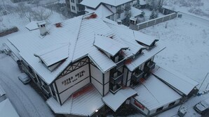 A hotel with a snow-covered roof and multiple floors. - Chalet & Hotel IDA (Bansko)