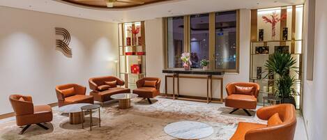 A modern living room with leather sofas, round coffee tables, and a large window.