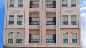 A multi-story building with balconies, a sign reading "ZAIBA HOTEL APARTMENTS," and a clear sky in the background. - AZAIBA HOTEL APARTMENT (Muscat)