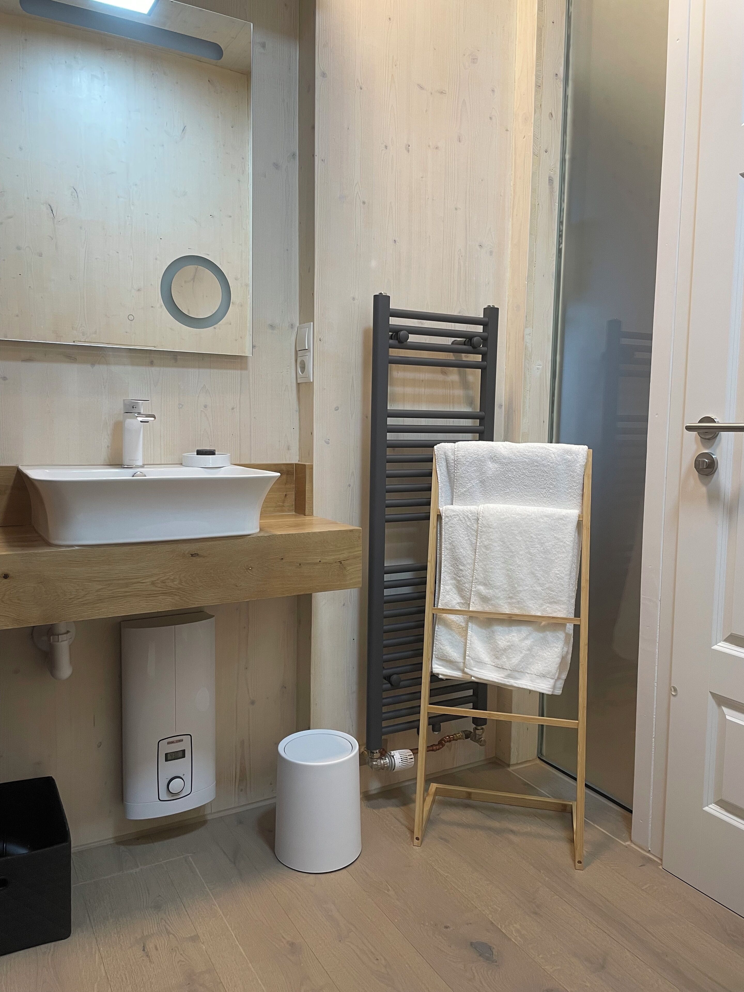 Un bagno con un mobile vanitario in legno, un lavandino bianco, un porta asciugamani e un water.