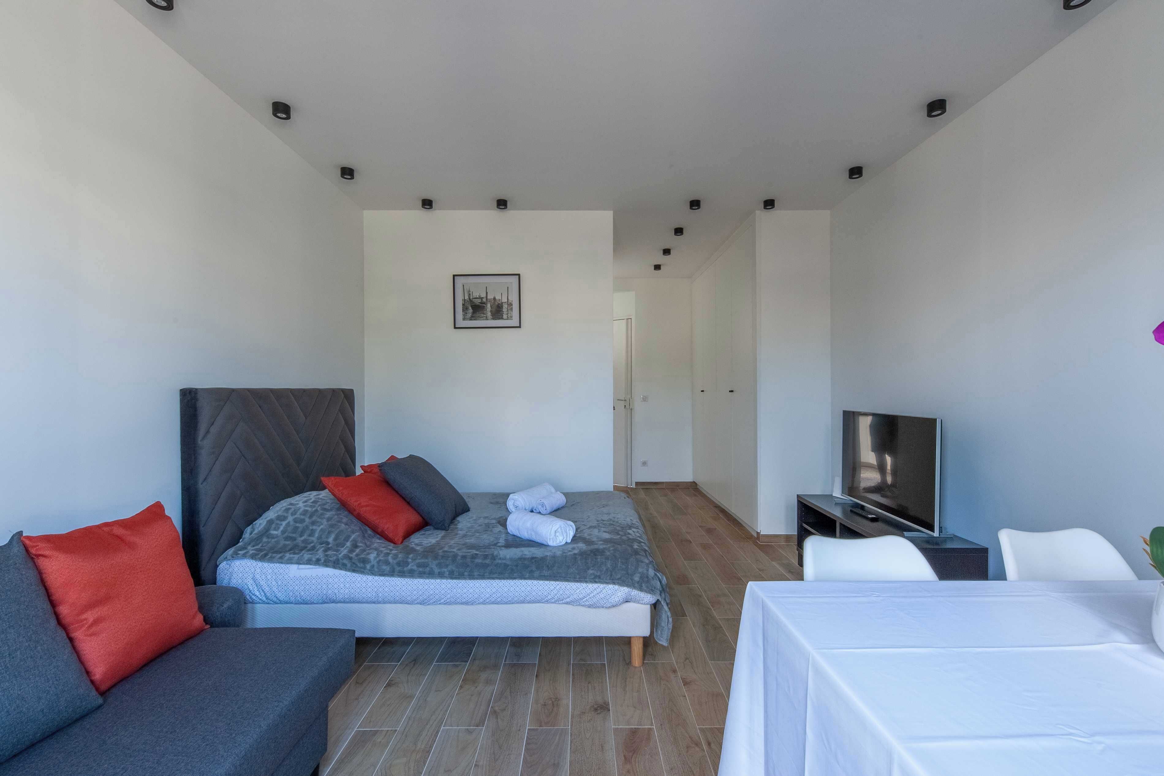 Une chambre d’hôtel moderne équipée d’un lit, d’une télévision, d’un canapé et d’une table à manger.