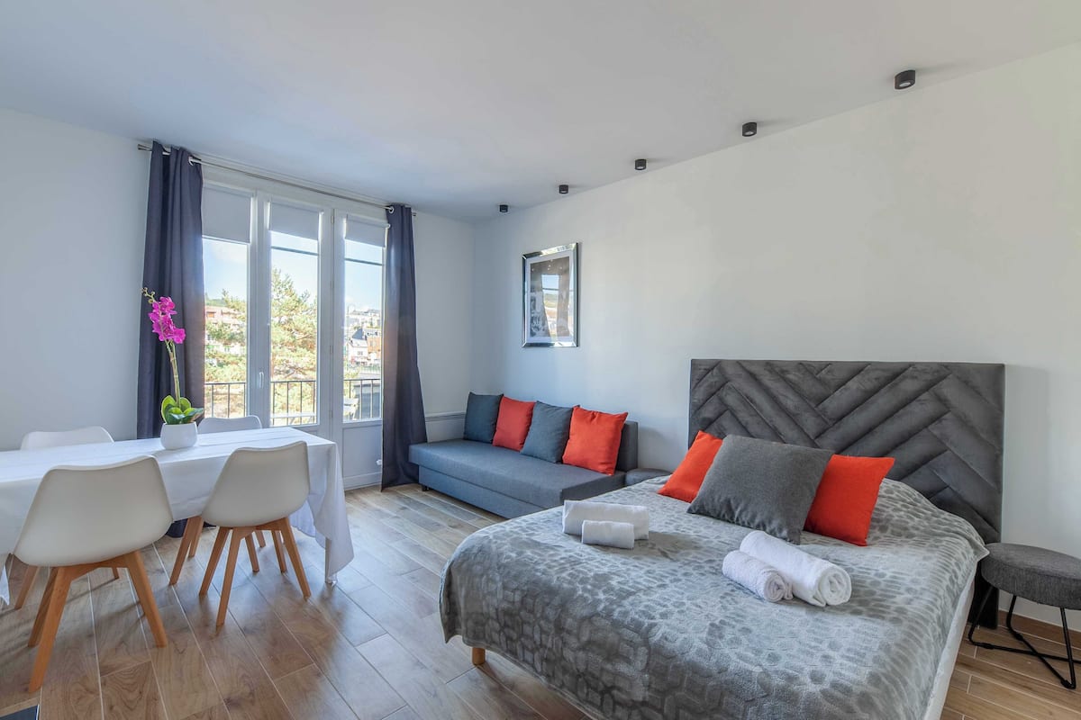 Une chambre d’hôtel moderne équipée d’un lit, d’un canapé, d’une table à manger et de chaises.