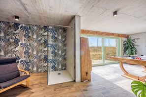 A room with a pool table, a chair, and a wall with a tropical leaf pattern. - Villa Olivia with Sauna (Piran)