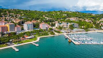 A coastal town with a marina, buildings, and a hilly backdrop.