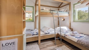 Een slaapkamer met een stapelbed, houten wanden, een raam en een bord met tekst.