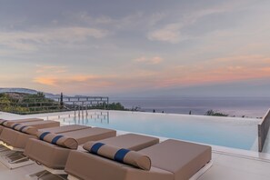 A poolside lounge with sun loungers and a view of the sea. - Archontiko Stoufi, an Authentic SeaView Retreat (VMHW+8F Skinaria, Greece)