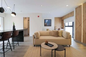 Relax in a spacious room with a central seating area, flat-screen TV, and large window offering a view.