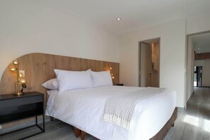 Relax in a serene space with a large bed and comfortable seating areas.