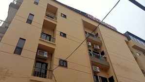 A multi-story building with balconies, air conditioning units, and a sign indicating it is a hotel. - Nest Hotel (Rawalpindi)