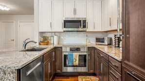 A modern kitchen with white cabinets, stainless steel appliances, and a granite countertop. - All Seasons | B1 - 3 Bedroom/ 2 bath condo Vail Village (Vail)