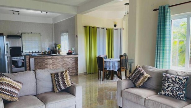 Un salon moderne avec deux canapés et un coin repas comprenant une table et des chaises.