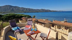 A terrace with a table, chairs, and a magazine. - Sublime new apartment on the beach in ST FLORENT, 5' from the center (Saint-Florent)