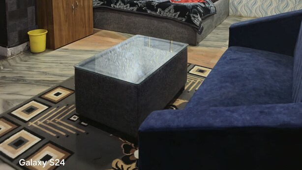 A modern bedroom with a bed, a wardrobe, a sofa, and a small table.