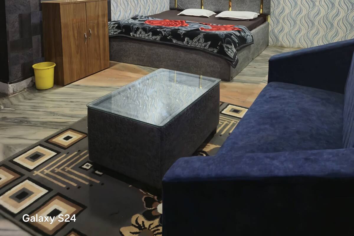 Een moderne slaapkamer met een bed, een kledingkast, een bank en een bijzettafeltje.
