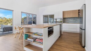 Eine moderne Küche mit weißen Schränken, einer Holz Arbeitsplatte und einem eingebauten Backofen.