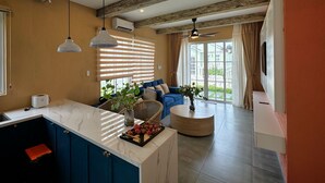 A modern kitchen with a marble countertop, blue cabinets, and a wooden ceiling. - Villa NovaWorld Phan Thiet 9 Trip STay (Tien Thanh)