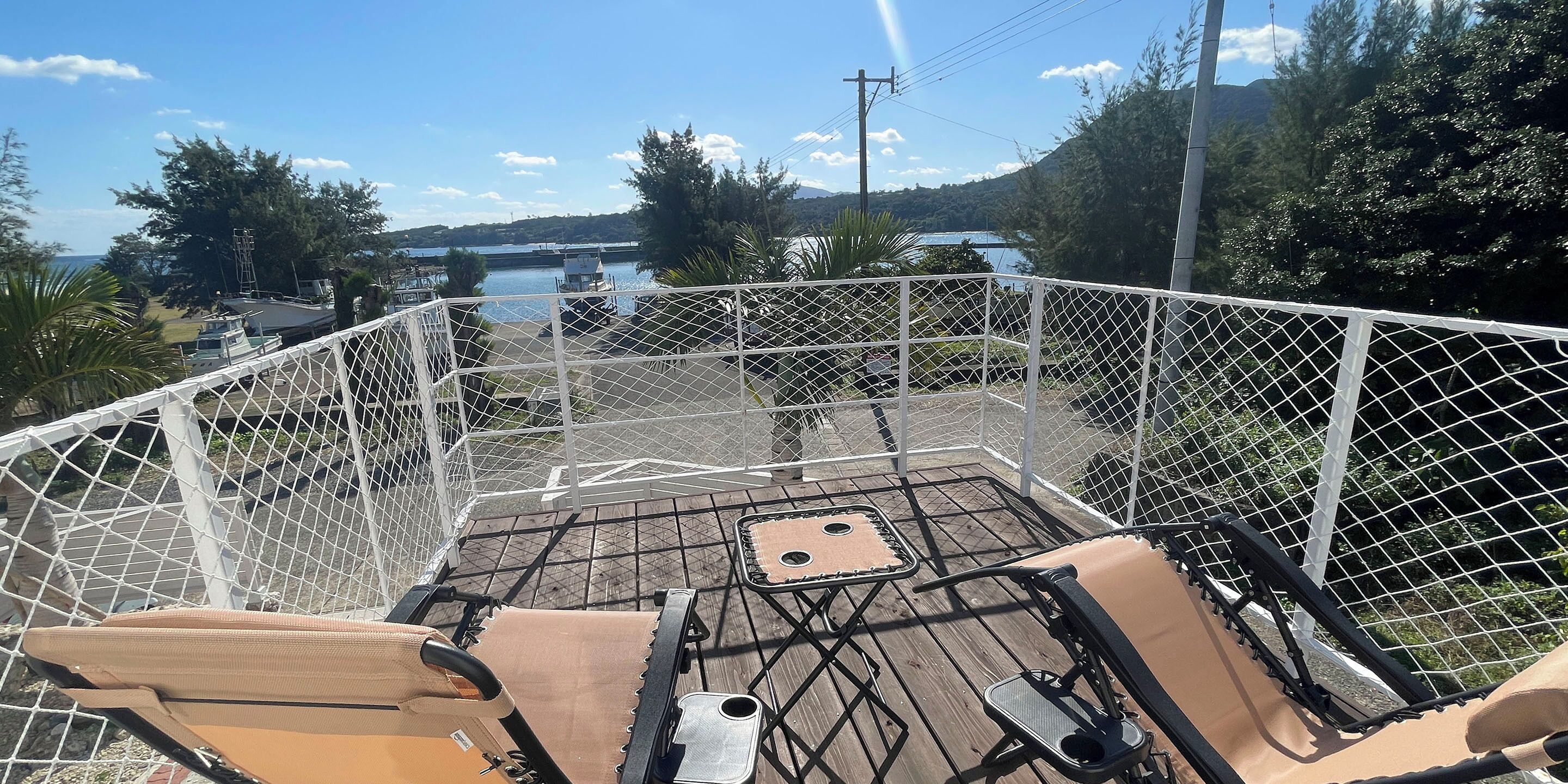 A covered outdoor seating area with a view of a lake and mountains.