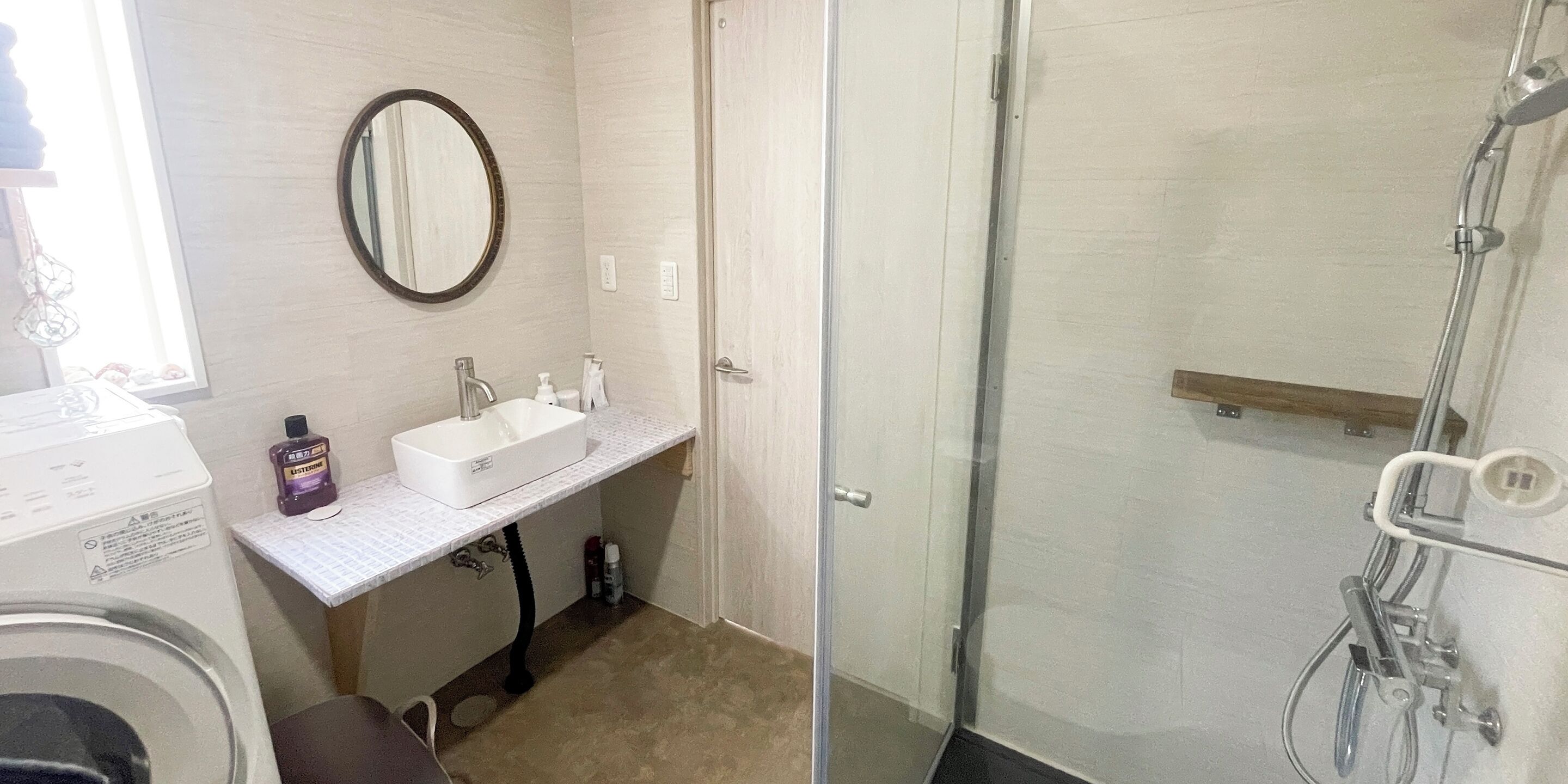 A bathroom with a white sink, mirror, and shower.