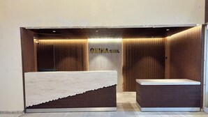 A reception area with a wooden panel design, a reception desk, and a wall with the name "OXINAGIZEL". - HOTEL OXINA CIIZEL (Kodaikanal)