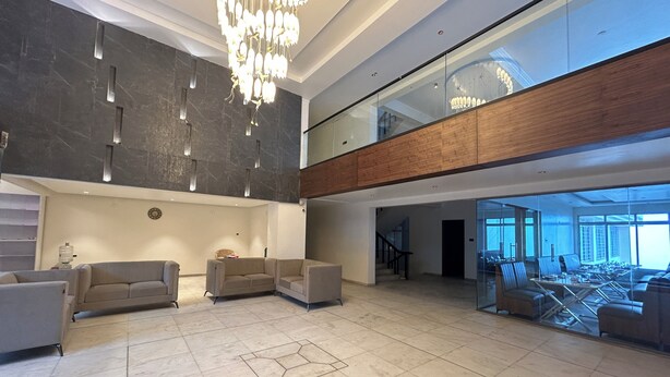 A spacious lobby with a high ceiling, a modern chandelier, and a seating area with sofas. - HOTEL OXINA CIIZEL (Kodaikanal)
