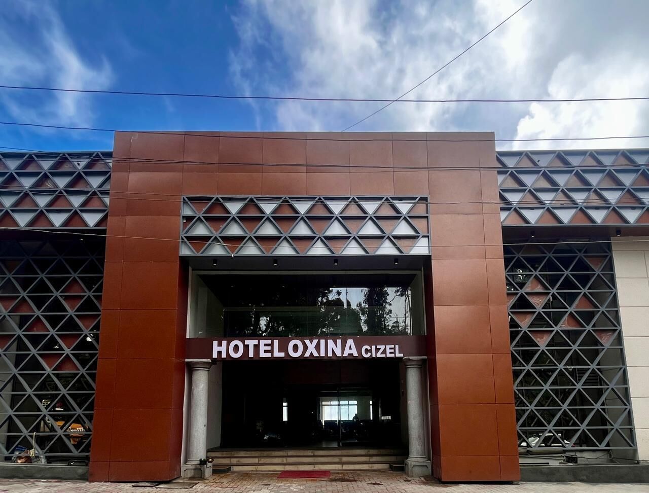 L'entrada d'HOTEL OXINA CIZEL, amb un disseny modern que destaca per dibuixos geomètrics i un accés ben visible.