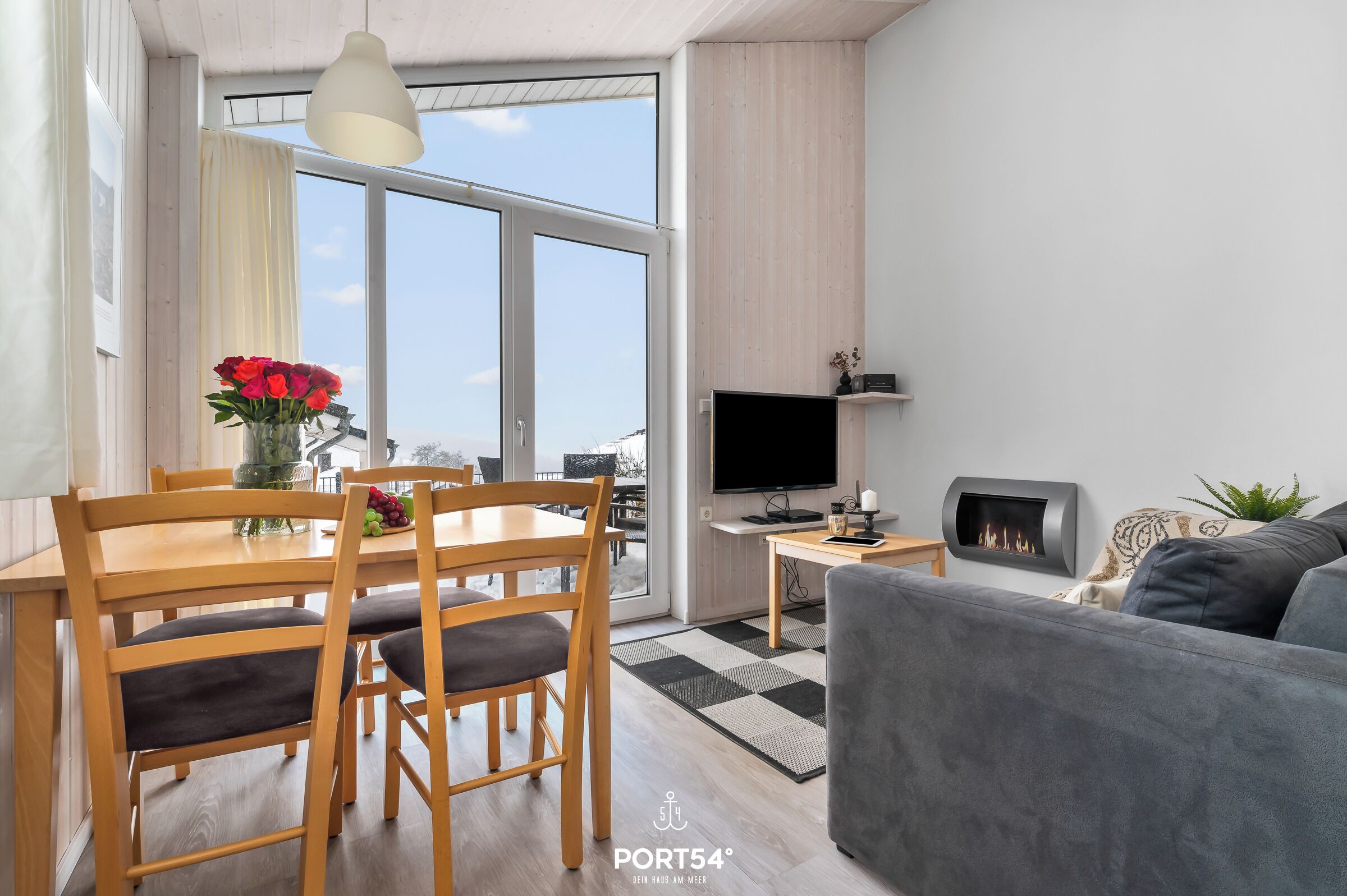 Ein modernes Wohnzimmer mit Essbereich, Flachbildfernseher und Kamin.