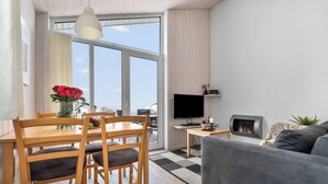 Un salon moderne comprenant un coin repas, un téléviseur à écran plat et une cheminée.