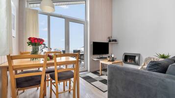 Ein modernes Wohnzimmer mit Essbereich, Flachbildfernseher und Kamin.