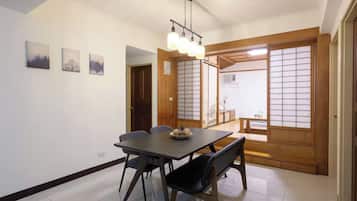 Un área de comedor con una mesa, sillas y una lámpara colgante.
