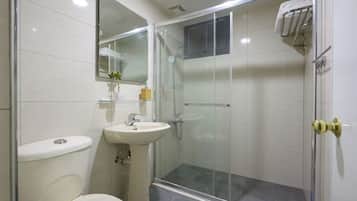 A modern bathroom with a toilet, sink, and glass-enclosed shower.