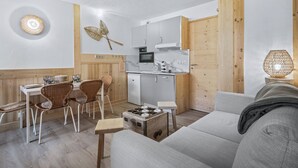 Un espace de vie compact comprenant une kitchenette, un coin repas et un coin salon.