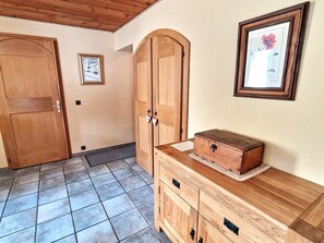 Una habitación con puertas y un armario de madera, y un cuadro en la pared.
