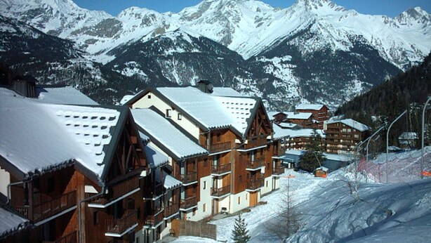 A snow-covered mountain town with wooden buildings and a ski slope. - Large apt 6/8 ppl, direct slopes access, near center, terrace (Valfréjus)