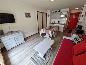 Cozy living space with a kitchenette, television, and sofa.