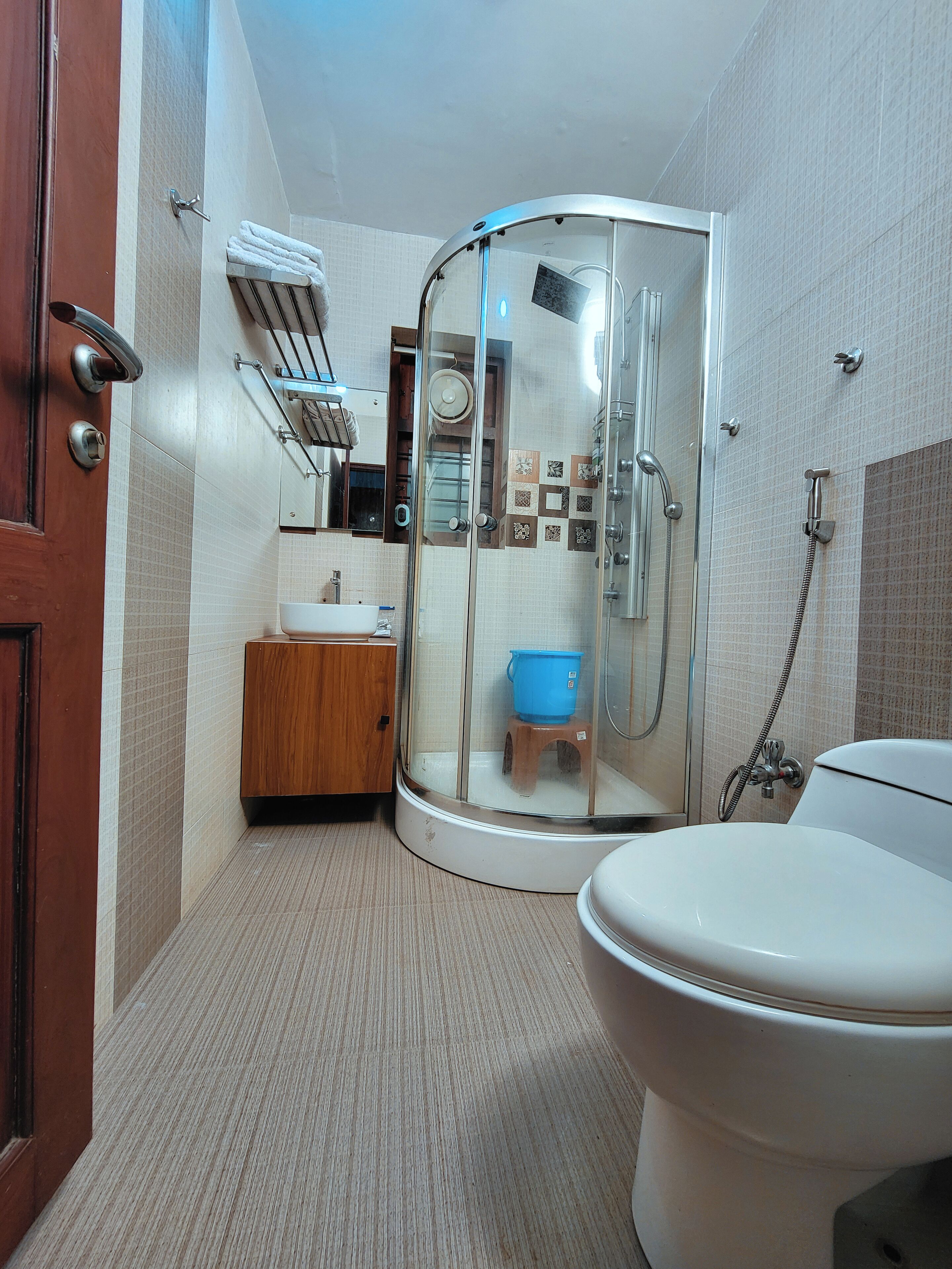 Une salle de bain avec une douche, un lavabo, des toilettes et un meuble en bois.