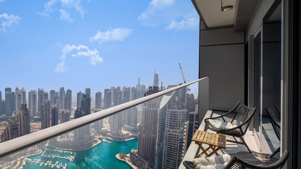 A balcony with a view of a cityscape and water.