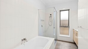 Une salle de bain moderne avec une douche à parois de verre, une baignoire et une fenêtre.