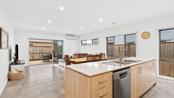 Una cocina moderna con una isla central, armarios de madera y lavavajillas.