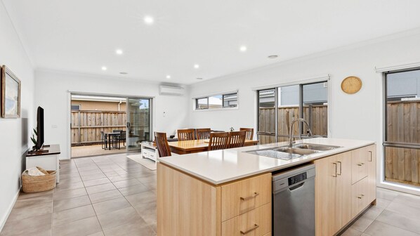 Une cuisine moderne dotée d’un îlot central, de meubles en bois et d’un lave-vaisselle.