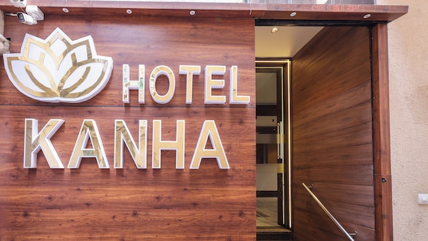 A wooden sign with the text "HOTEL KANHA" and a lotus flower logo. - KANHA HOTEL (Nathdwara)