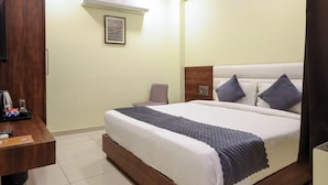 A hotel room with a bed, a desk, and a television. - KANHA HOTEL (Nathdwara)