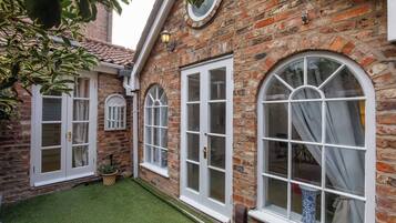 A brick building with white-framed windows and a small lawn area.