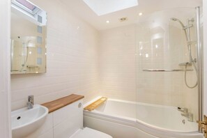 A modern bathroom with a glass-enclosed shower, a sink, and a toilet.
