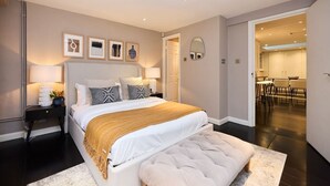A modern bedroom with a large bed, bedside tables, a mirror, and a view into a dining area. - The Notting Hill Gate Crib - Relaxing 2bdr House (London)