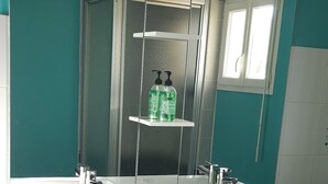 Un baño moderno con un espejo grande, dos lavamanos y una ventana.